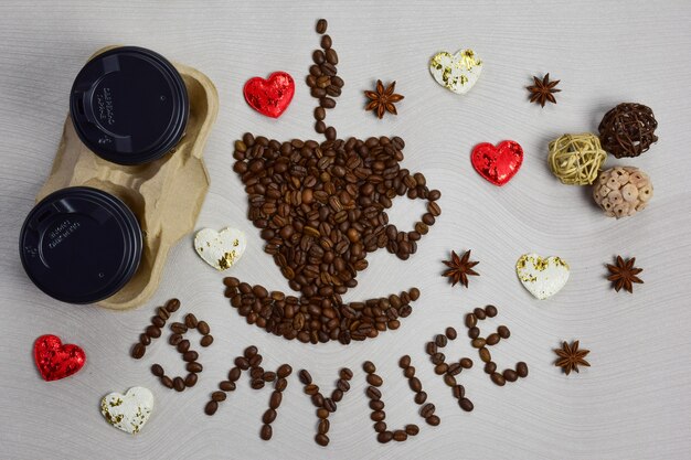 La figura con forma de taza de café con platillo está hecha de granos de café.