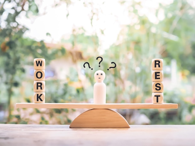 Figura humana de madera con signos de interrogación La elección entre trabajo y descanso.