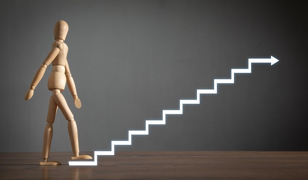 Figura humana de madera subiendo escaleras Carrera empresarial