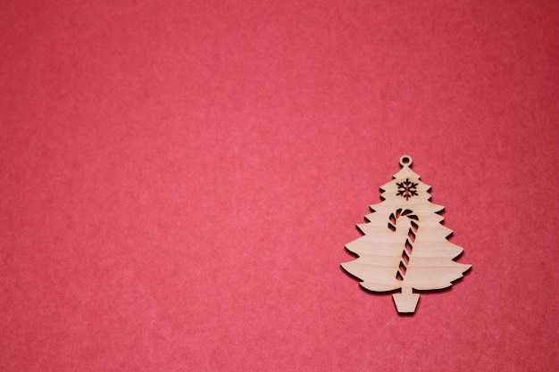 Figura de madera del árbol de navidad en un fondo rojo. Copia espacio
