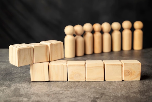 Una figura de madera y una fila de cubos de madera