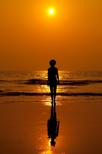 Figura de una mujer en el fondo del mar y puesta de sol.