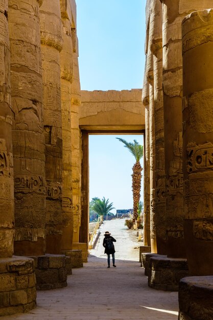 Figura de mujer solitaria entre las columnas de la gran sala hipóstila del templo de Karnak