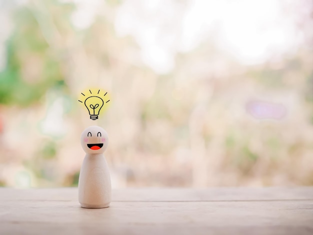 Figura de negocios de madera con bombilla para el concepto de innovación de ideas creativas de liderazgo