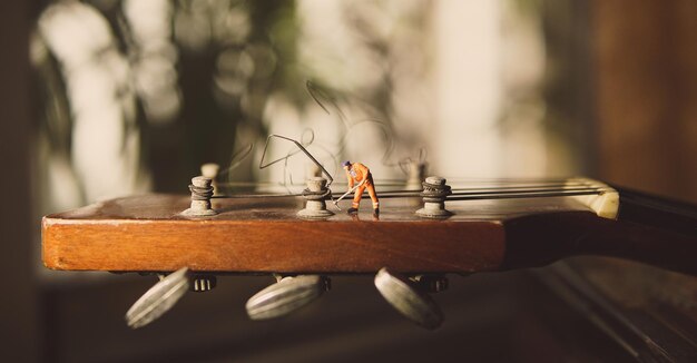 La figura del trabajador técnico arreglando viejas cuerdas de guitarra.