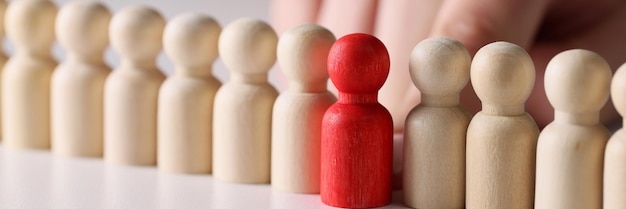 Figura vermelha de madeira em várias figuras brancas de madeira seguidas agressão do conceito de close-up em