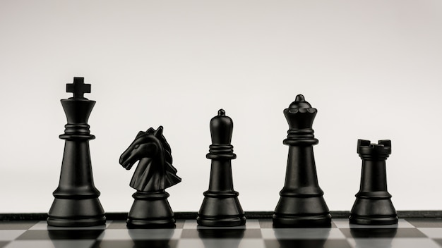Figuras de ajedrez negras a bordo.- Idea de negocio para la competición. - Concepto de éxito y liderazgo.