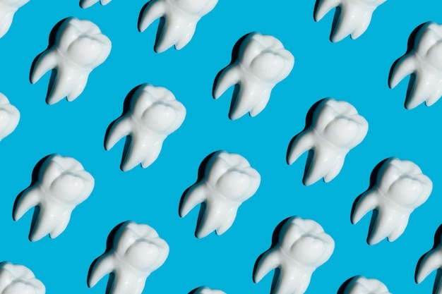 Figuras blancas de dientes sobre un fondo azul Concepto de odontología