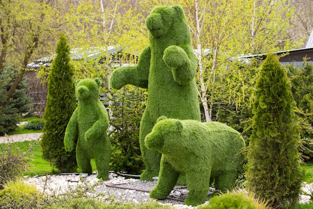 Figuras de jardim de três ursos em um fundo verde