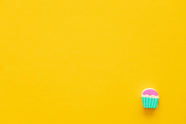 Figuras de madeira coloridas em forma de bolos em um fundo amarelo