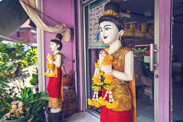 Figuras decorativas de mulheres na entrada do salão de massagens tailandesas em Bangkok, Tailândia