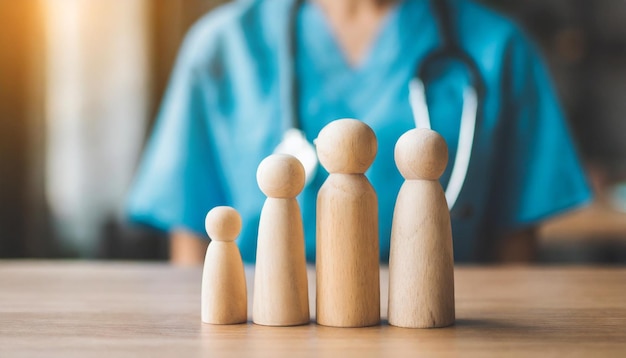 figuras familiares de madera en miniatura en una mesa de médicos que simbolizan la unidad y el apoyo a la atención médica en un c