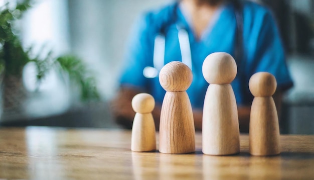 figuras familiares de madera en miniatura en una mesa de médicos que simbolizan la unidad y el apoyo a la atención médica en un c