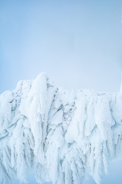 Figuras de hielo bajo una gran cantidad de hielo y nieve sobre fondo azul claro