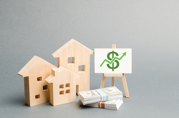 Figuras de madera de casas y un cartel con dinero.