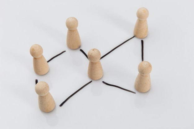 Foto figuras de madera de personas en una mesa blanca, concepto de negocio, recursos humanos y concepto de gestión.