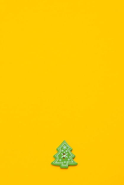 Figuras de madera verde en forma de árbol de Navidad sobre un fondo amarillo Concepto de Año Nuevo