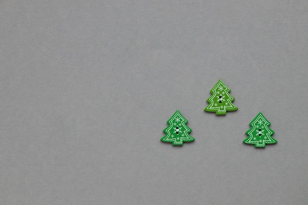 Figuras de madera verde en forma de árbol de Navidad sobre un fondo gris Concepto de Año Nuevo