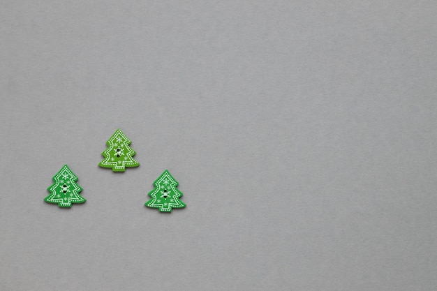 Figuras de madera verde en forma de árbol de Navidad sobre un fondo gris Concepto de Año Nuevo