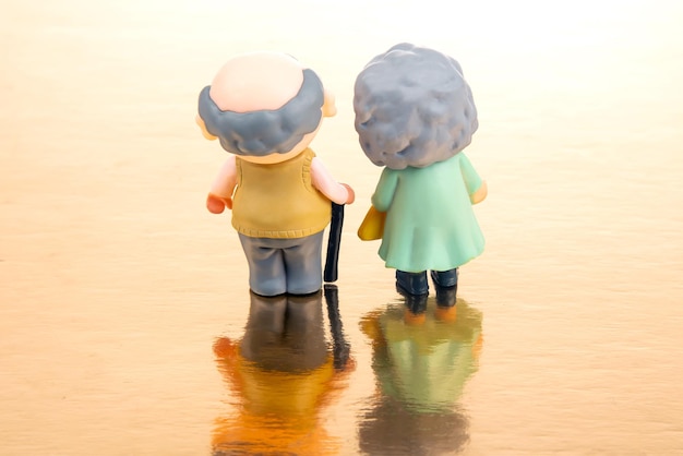 Figuras de personas en miniatura para el concepto de que un par de jubilados caminan juntos actitud y amistad en la vejez