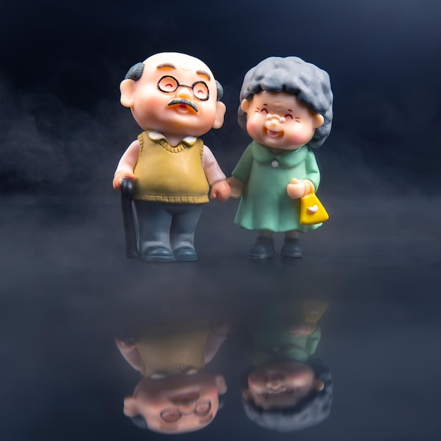 Figuras de personas en miniatura para el concepto de que un par de jubilados caminan juntos actitud y amistad en la vejez