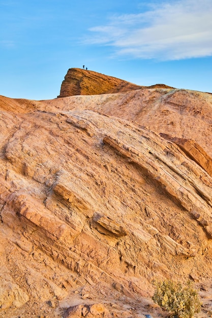 Figuras solitárias no topo de grandes formações rochosas vermelhas no deserto