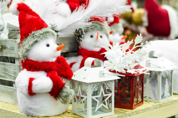 Figuras tradicionales de juguetes de navidad para la decoración del hogar en año nuevo. pequeño muñeco de nieve de juguete, en rojo sombrero de santa, candelabro.