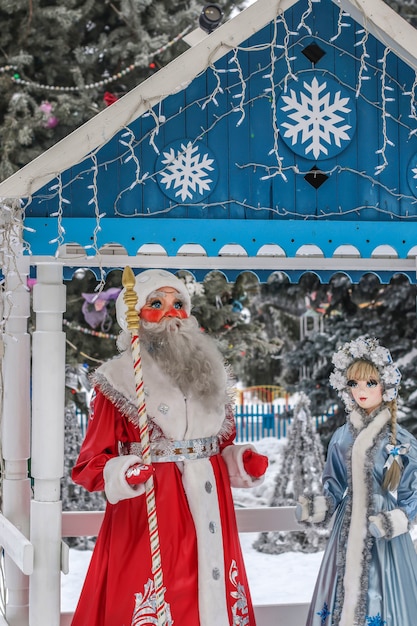 Figuren von Snegurochka und Santa Claus in einer Neujahrslaube in einem Freiluftpark, einem Erholungsgebiet für Kinder und Erwachsene in den Neujahrsferien