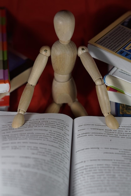 Foto figurina de madera con libro abierto