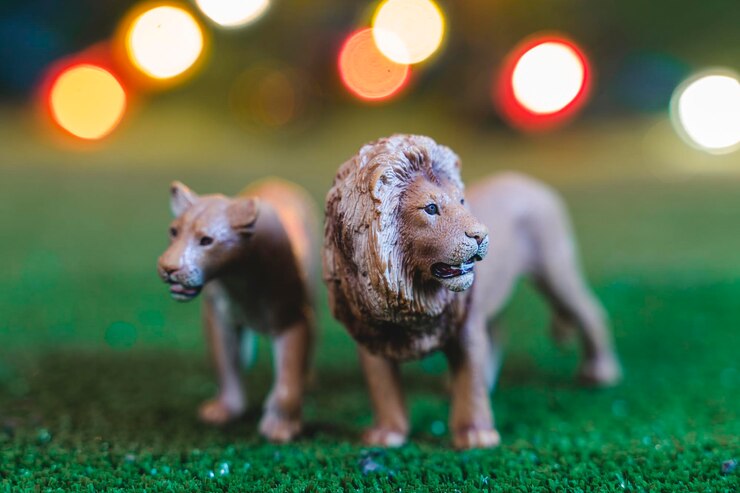 Foto figurinhas de plástico de um casal de leões em um ambiente semelhante a uma savana à noite brinquedo de crianças