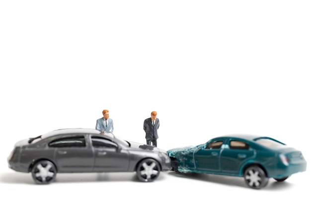 Figuritas y coches de juguete rotos sobre un fondo blanco