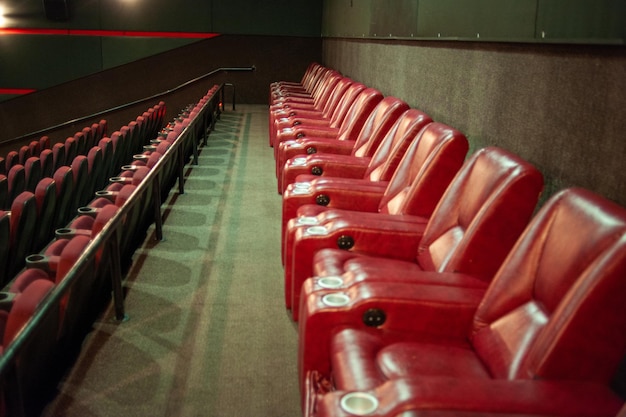 Una fila de asientos rojos en un teatro.