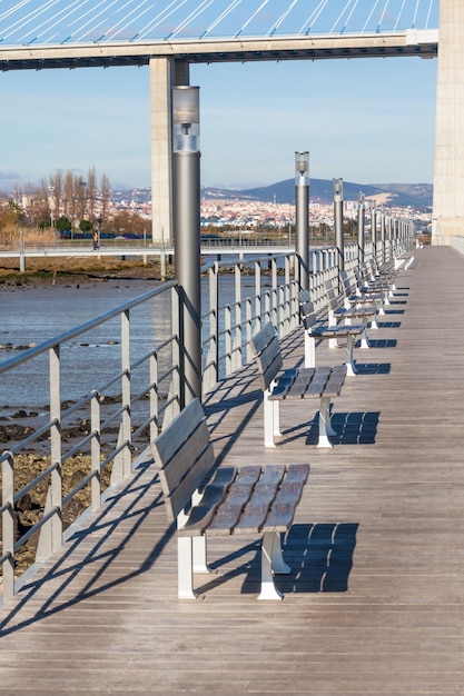 Fila de bancos de madera en el terraplén del río