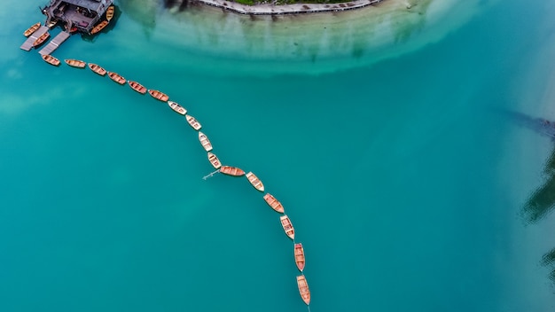 Fila de barcos en el lago Braies en Italia