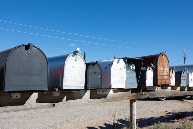 Una fila de buzones están alineados en fila, uno de los cuales dice la palabra correo.