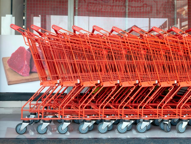 Una fila de carritos de compras rojos en un supermercado moderno
