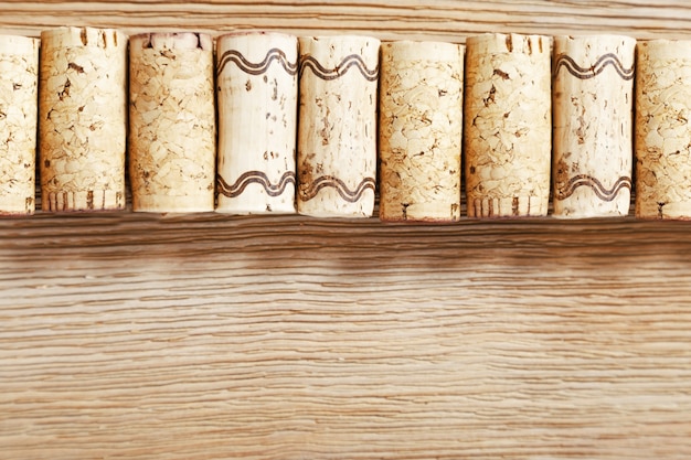 Una fila de los corchos viejos del vino en un fondo de madera.