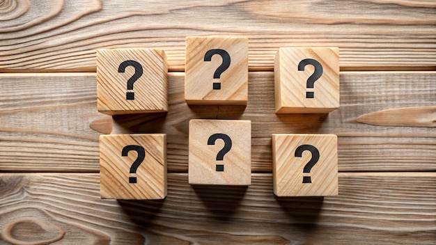 una fila de cubos de madera con signos de interrogación en ellos