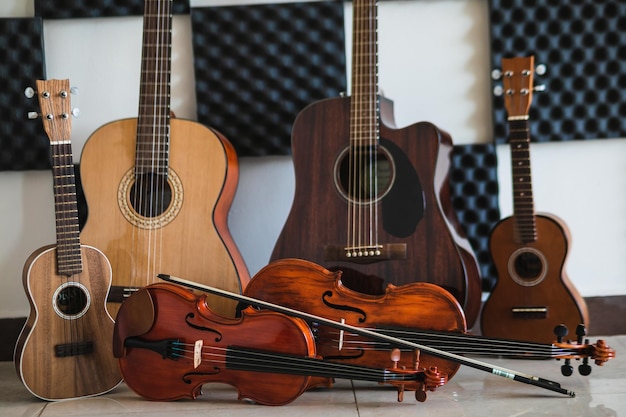 Fila de diferentes instrumentos musicais de cordas para uma escola de música