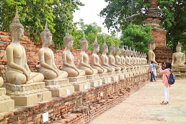 Foto fila de imagens de buda no templo antigo de wat yai chai mongkhon no parque histórico de ayutthaya tailândia
