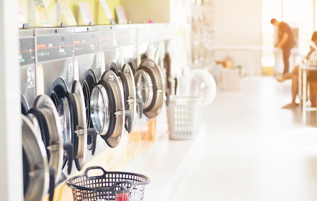 Foto fila de máquinas de lavar roupa industrial na lavanderia em uma lavanderia pública, com lavanderia em uma cesta, tailândia