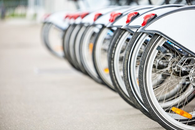 Fila de rodas traseiras de bicicletas estacionadas na estação de aluguel