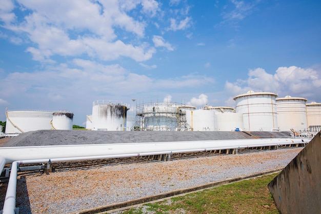 Fila de grandes tanques blancos para petróleo y gas de tuberías largas de acero de gasolina