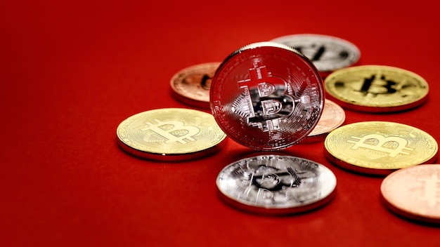 Fila de grupo de monedas de criptomoneda de diferentes colores sobre fondo rojo. Idea para un nuevo tipo de dinero en la economía del mundo empresarial.