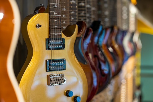 Fila de guitarras eléctricas de diferentes colores en una tienda de instrumentos musicales