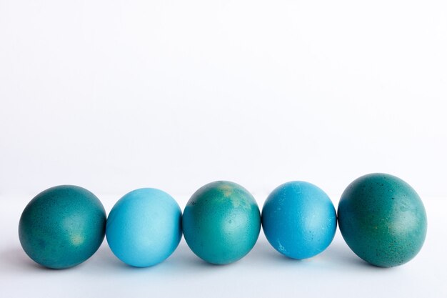 Fila de huevos de Pascua azul ombre aislado en la pared blanca