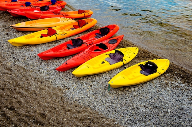 Foto una fila de kayaks amarillos se alinean en la orilla.