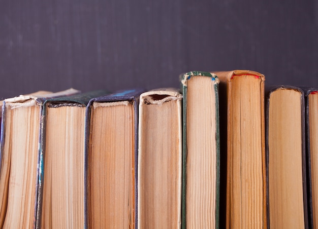 Fila de libros antiguos en el fondo del tablero de tiza