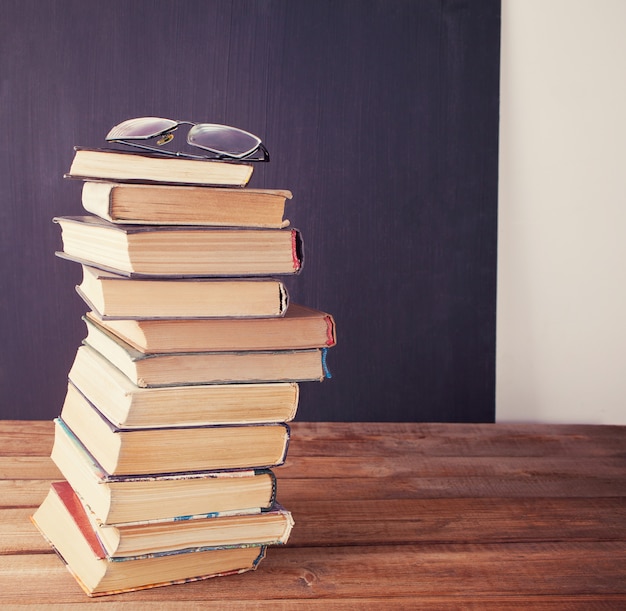 Fila de libros antiguos en el fondo del tablero de tiza