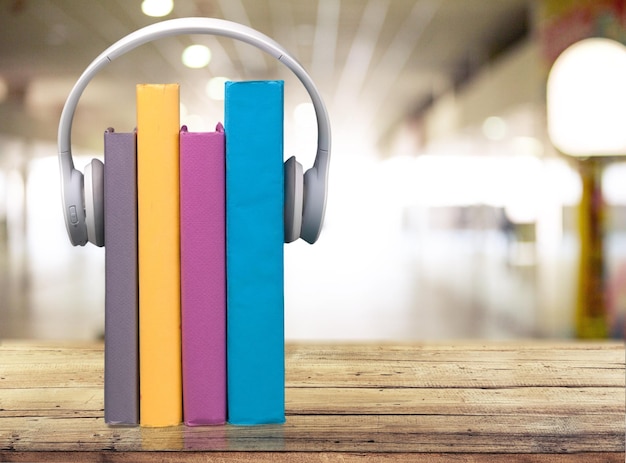 Una fila de libros y auriculares en una mesa de madera